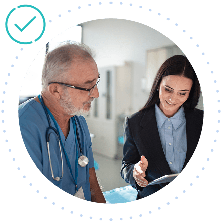 A veterinarian and a businesswoman discuss content on a digital tablet in a medical office.